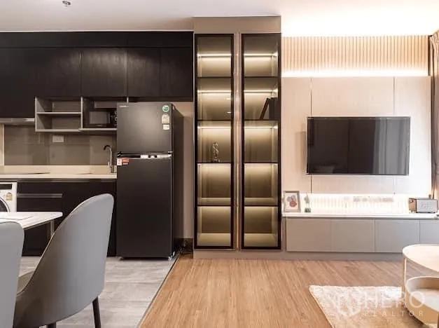 Condominium for rent in Watthana, Bangkok - Modern kitchen wall with glass cabinets, fridge and TV console.