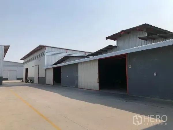 工厂 出租在Phra Pradaeng, Samut Prakan - 多联排仓库单元外观，宽敞出入口及硬化车道便于卡车通行。