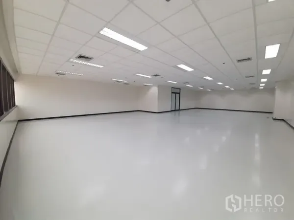 办公空间 出租在Bang Rak, Bangkok - 宽敞办公室楼层，吊顶灯与一侧的长窗带。