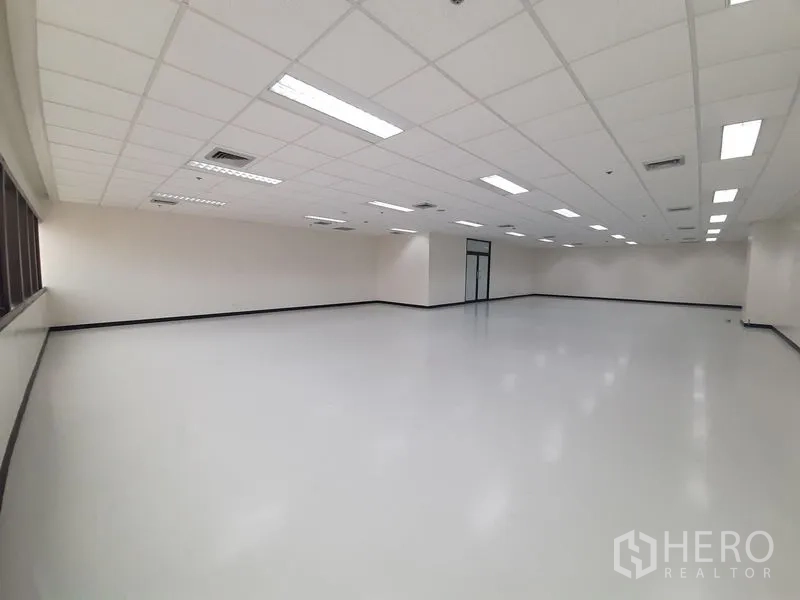 办公空间 出租在Bang Rak, Bangkok - 宽敞办公室楼层，吊顶灯与一侧的长窗带。