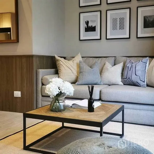 公寓 出租在Bang Rak, Bangkok - 暹罗Silom公寓客厅，灰色沙发、木质茶几与墙面装饰画。