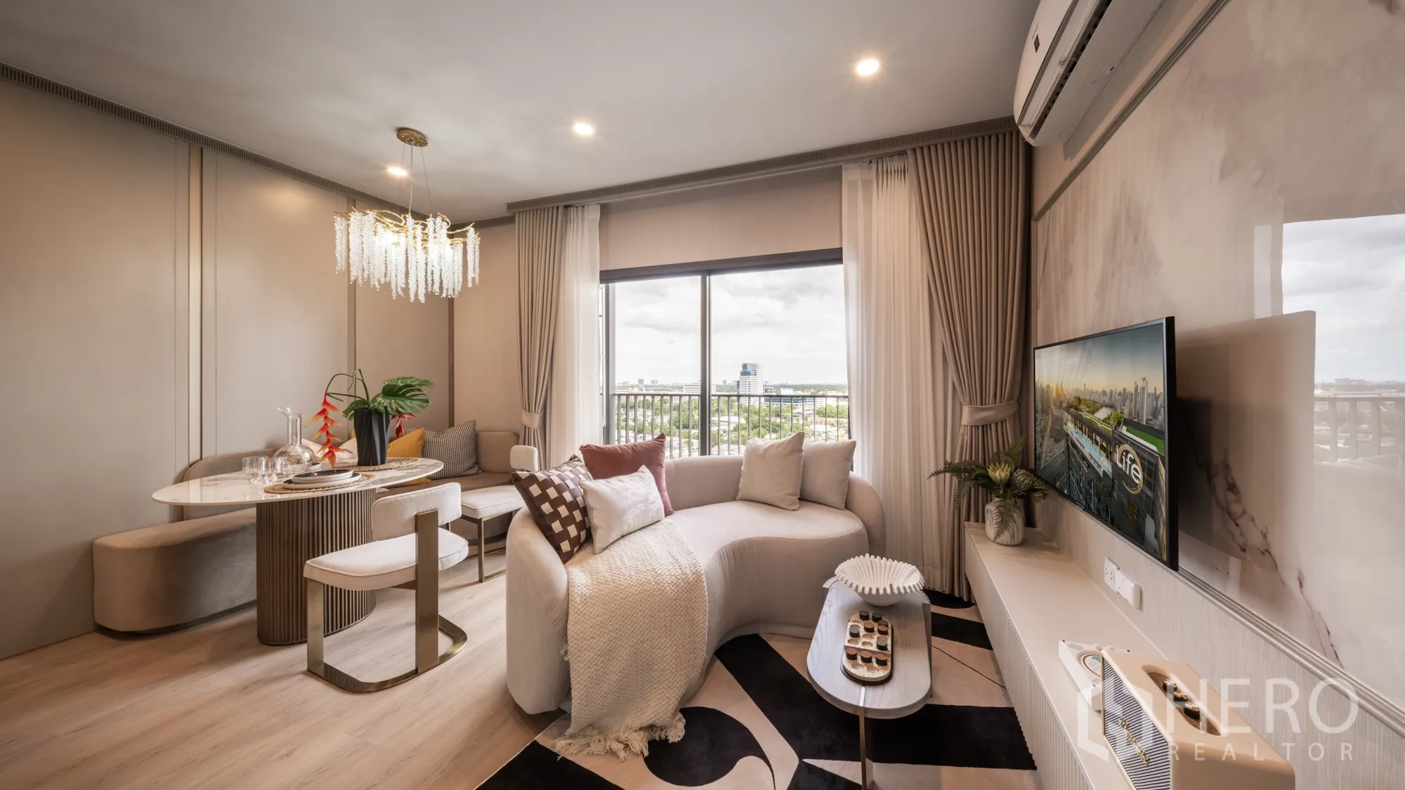 公寓 for sale in Khlong Toei, Bangkok - 明亮的起居与用餐区，弧形沙发、水晶吊灯、电视墙，大窗景观城市。