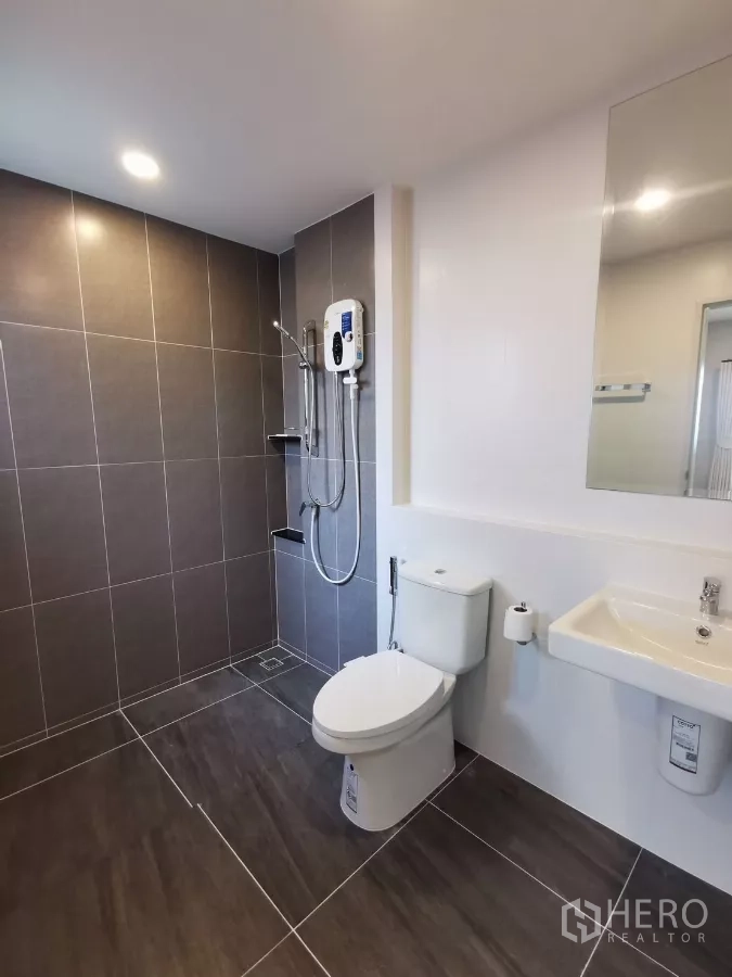 Detached House for rent in Bang Phli, Samut Prakan - Contemporary bathroom finished in gray tiles with shower and sanitary ware.