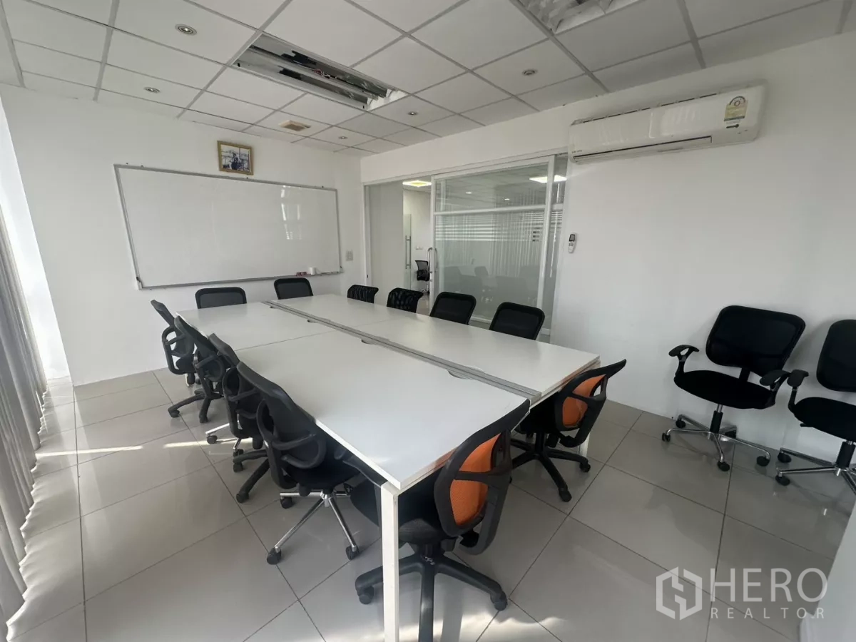 Office Space for rent in Huai Khwang, Bangkok - Furnished conference room with long white table, many chairs, whiteboard and wall-mounted AC.