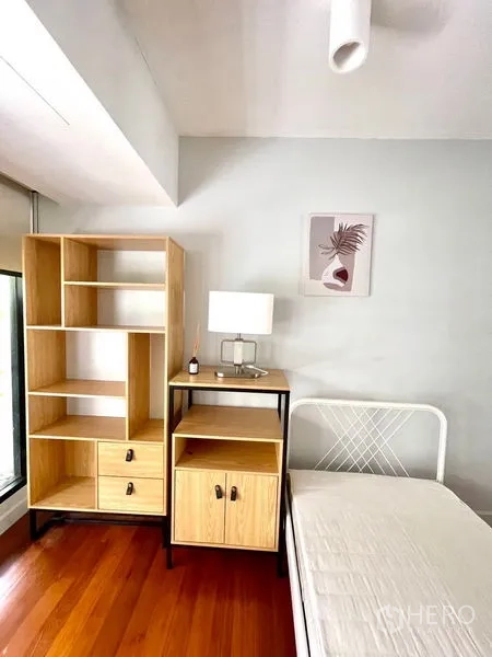 Townhouse for rent in Khlong Toei, Bangkok - Single bedroom corner with open shelves, bedside cabinet and balcony light.