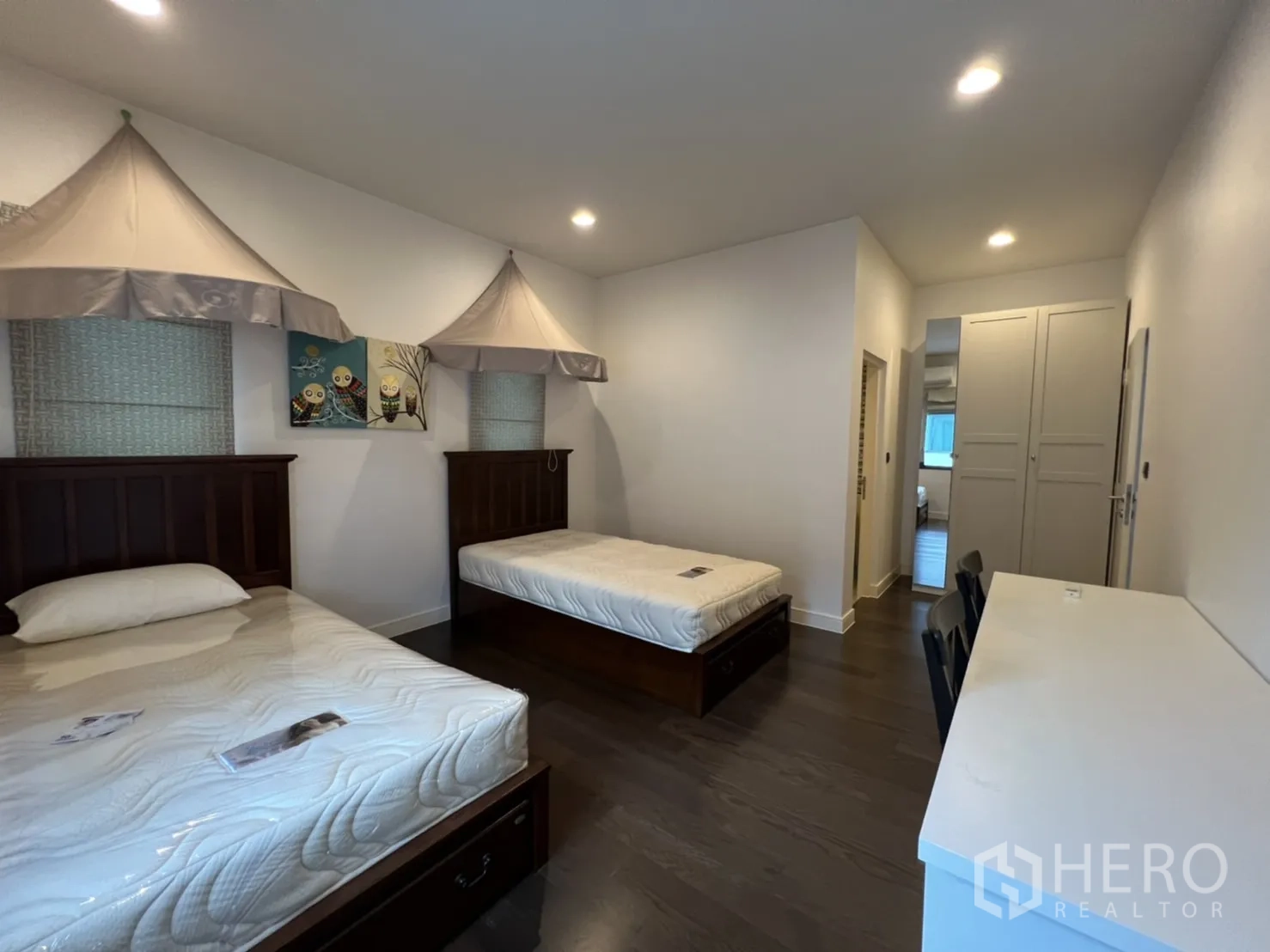 Detached House for rent or sale in Bang Kapi, Bangkok - Family bedroom with two single beds, study desk and built-in storage drawers.