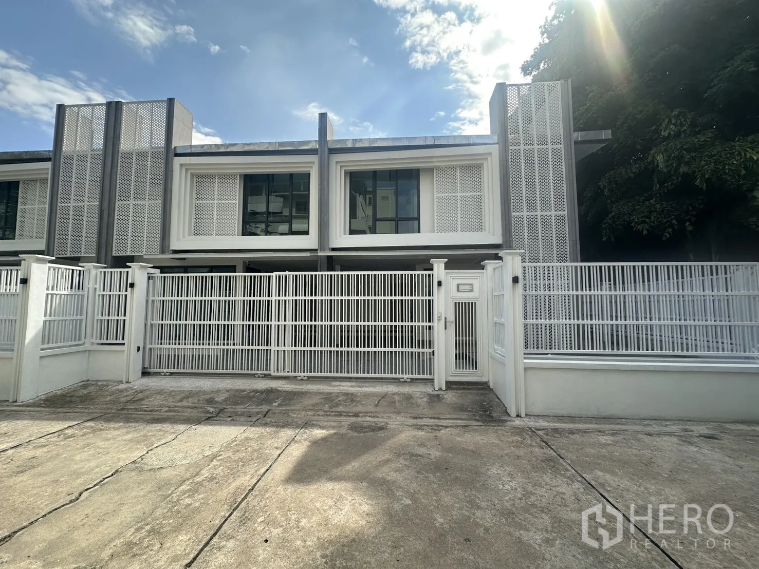 联排别墅 出租在Watthana, Bangkok - 现代两层联排别墅外观，白色金属围栏与车道，位于曼谷瓦他那区。