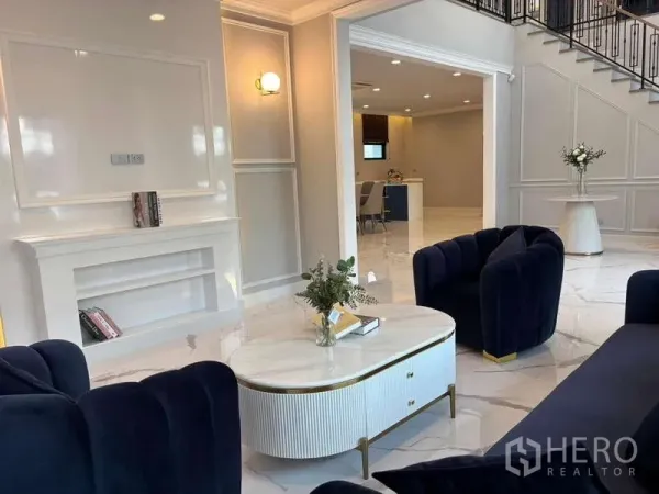 Detached House for rent in Bang Phli, Samut Prakan - Bright living room with navy sofas, white coffee table and marble floors connecting to the dining area.