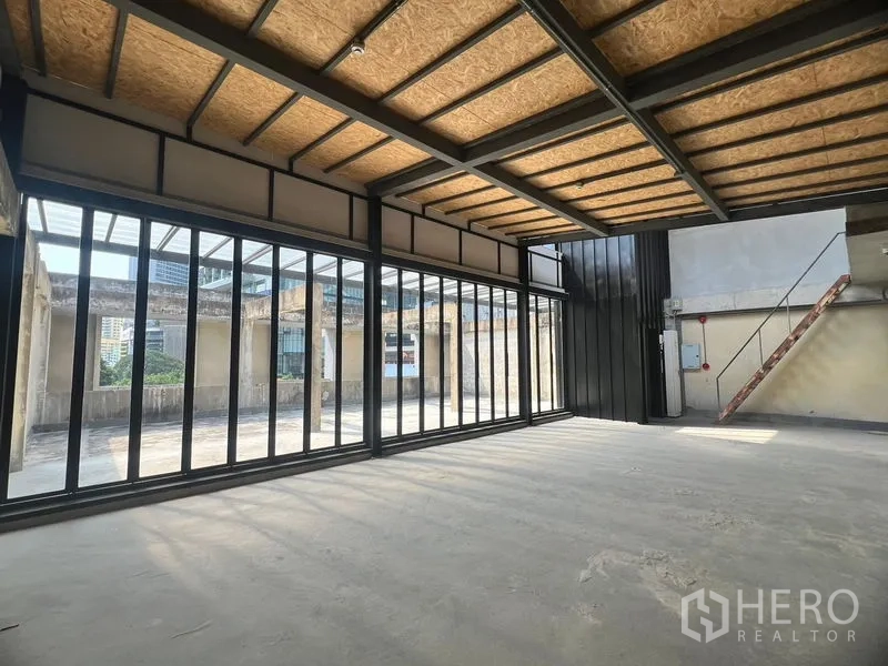 零售空间 出租在Watthana, Bangkok - 大开间室内，巨幅推拉玻璃门通向露台，外露钢梁天花