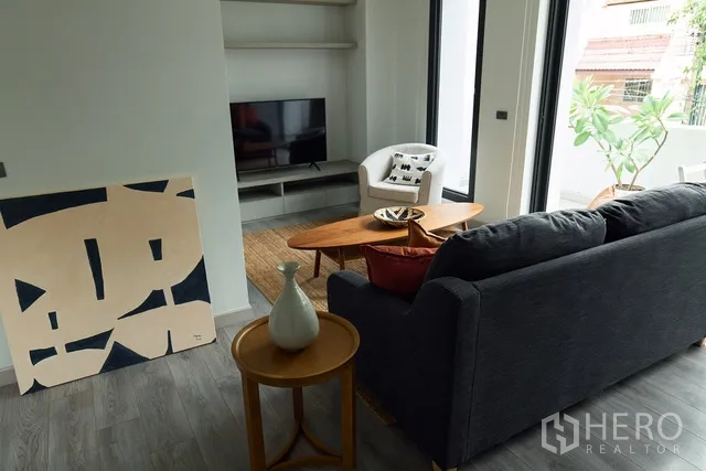 联排别墅 出租在Watthana, Bangkok - 起居区配电视柜与茶几，可通往绿意阳台。