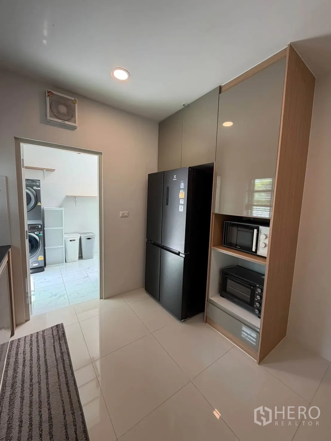 บ้านเดี่ยว for rent in Bang Phli, Samut Prakan - ครัวพร้อมตู้เย็นสีดำ ไมโครเวฟและเตาอบบิลต์อิน มีห้องซักรีดด้านนอก.