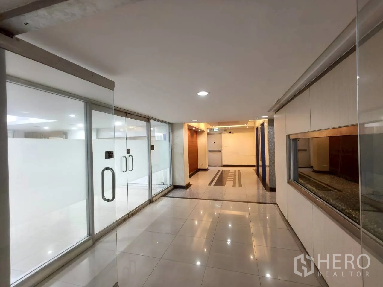 ออฟฟิศ for rent in Chatuchak, Bangkok - ทางเดินส่วนกลาง หน้าร้านกระจกและพื้นกระเบื้องเงา.