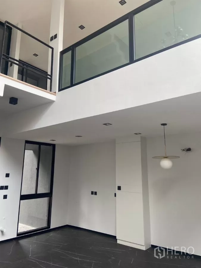 ทาวน์เฮาส์ ให้เช่าในHuai Khwang, Bangkok - ชั้นลอยราวกันตกกระจก มองลงสู่พื้นที่นั่งเล่นแบบโอเพ่นสเปซ.