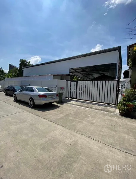 货栈 出租在Bang Khen, Bangkok - 街景正门，滑动金属大门与路边停车