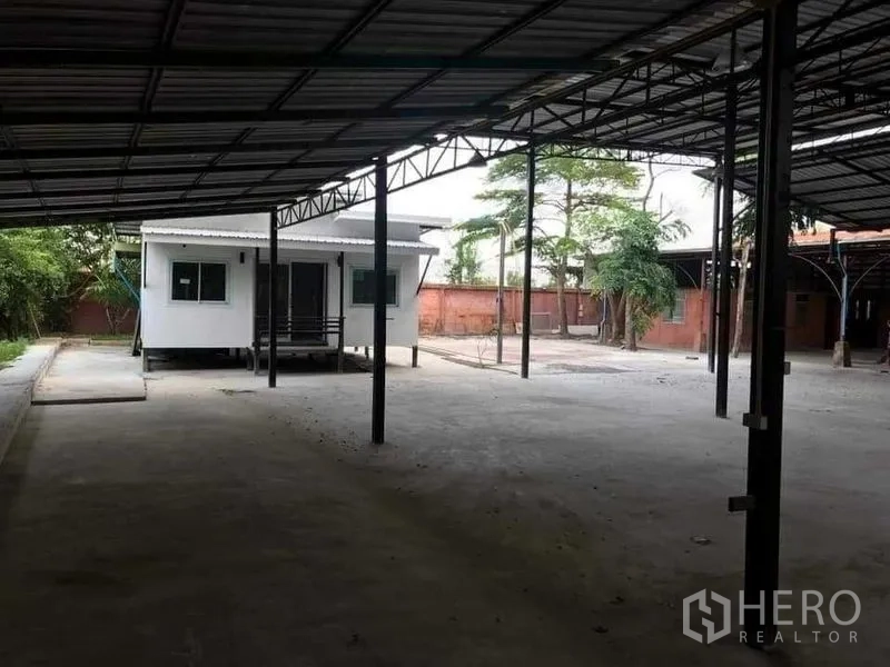คลังสินค้า ให้เช่าหรือขายในKhlong Sam Wa, Bangkok - ลานคลุมหลังคาพร้อมออฟฟิศโมดูลาร์สีขาวข้างโกดัง
