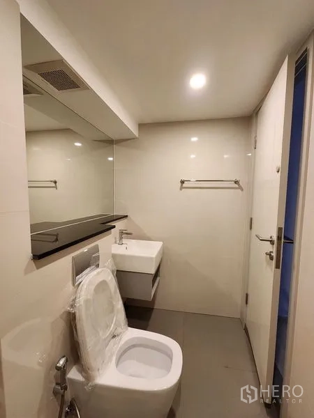 คอนโด ขายในSathon, Bangkok - ห้องน้ำมินิมอล อ่างล้างมือแขวนผนัง โถสุขภัณฑ์ และไฟดาวน์ไลท์