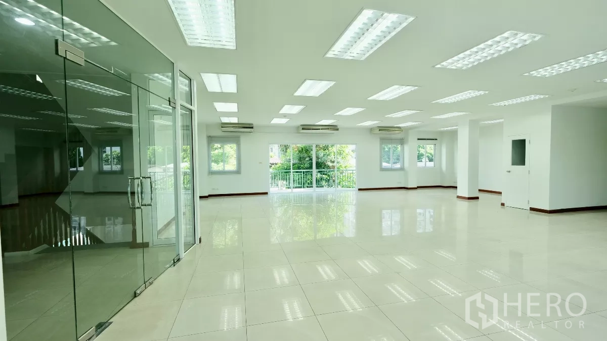 Office Space for rent - Open workspace with glass partition entry, glossy tile flooring, LED lights, and green views.