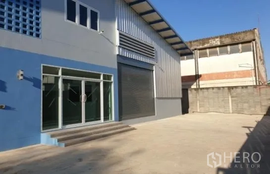 คลังสินค้า ให้เช่าในPrawet, Bangkok - ด้านนอกโกดังพร้อมสำนักงานกระจก ประตูม้วน และลานคอนกรีตกว้าง