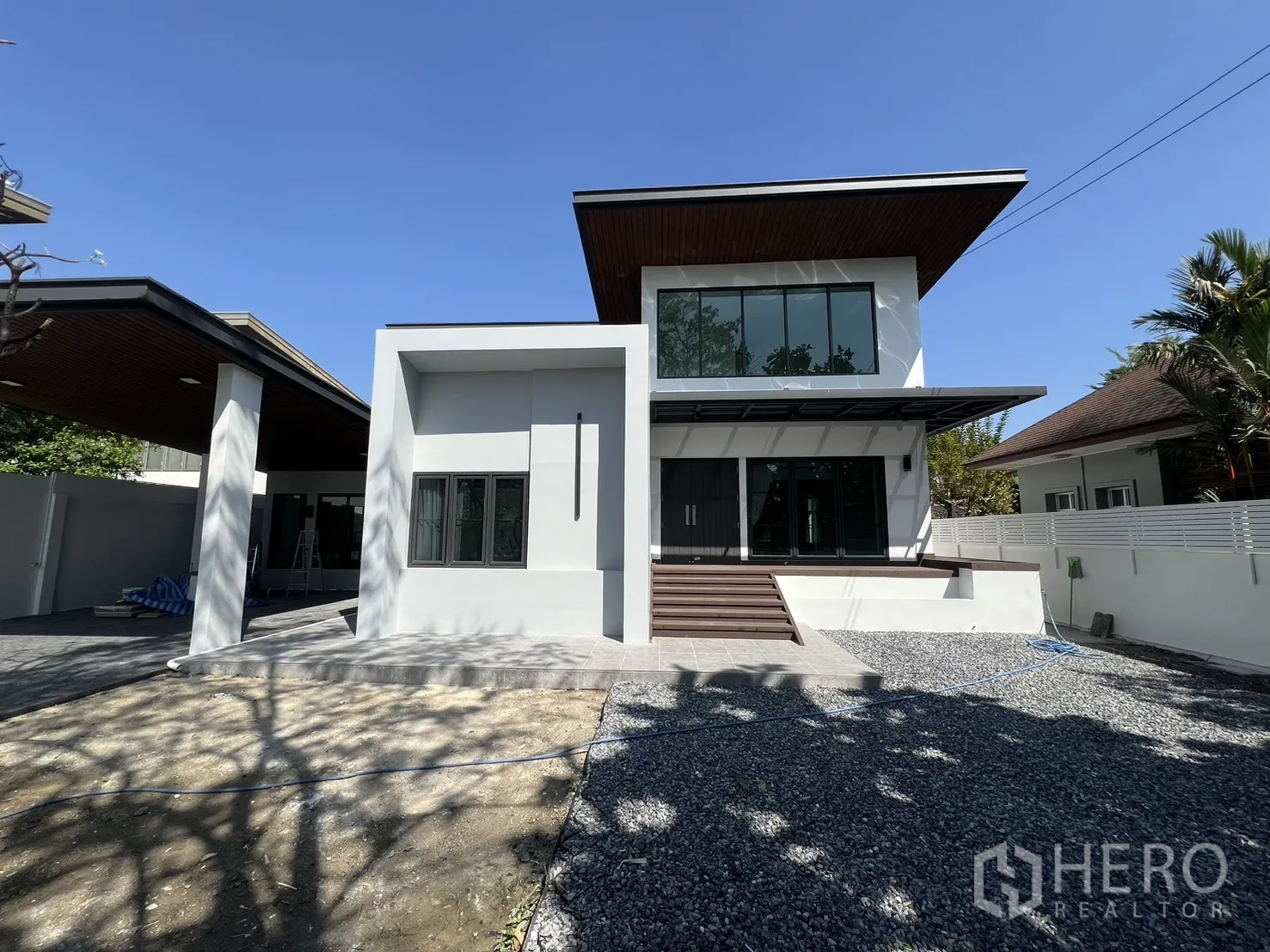 Detached House for rent in Saphan Sung, Bangkok - Full front view of modern two-storey house with fenced boundary and open yard.