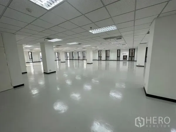 Office Space for rent - Bright vacant office space with glossy flooring, multiple pillars, and perimeter windows for natural light.