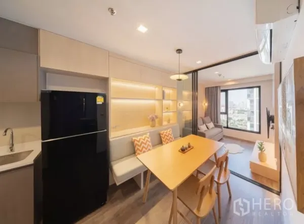 คอนโด ให้เช่าในChatuchak, Bangkok - ครัวและพื้นที่ทานอาหารพร้อมชั้นโชว์ไฟในตัว เชื่อมต่อห้องนั่งเล่นที่มีหน้าต่างบานใหญ่