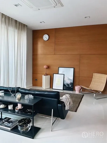 Detached House for sale in Bang Kapi, Bangkok - Bright living room with wood accent wall, sheer curtains, and modern lounge seating.