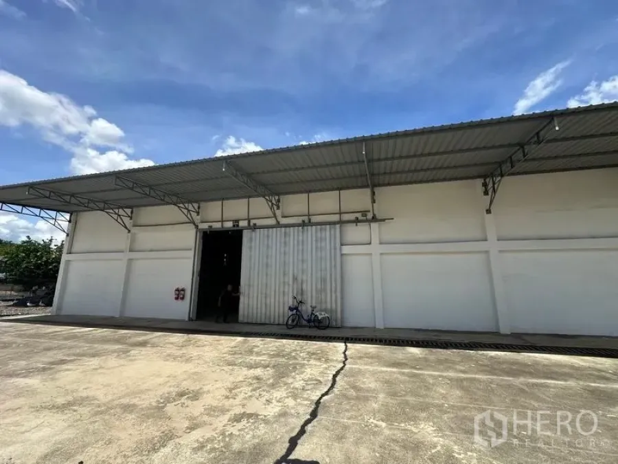 货栈 出租在Mueang Pathum Thani, Pathum Thani - 仓库内部广角图，钢结构屋架、混凝土地面与开放入口。