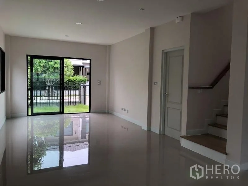 Detached House for sale in Bang Phli, Samut Prakan - Living room with sliding doors to garden and staircase to upper floor
