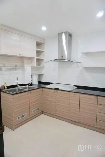 บ้าน ให้เช่าในSuan Luang, Bangkok - ครัวรูปตัวแอล ตู้ลายไม้ เคาน์เตอร์สีดำ อ่างล้างจาน และเครื่องดูดควัน.