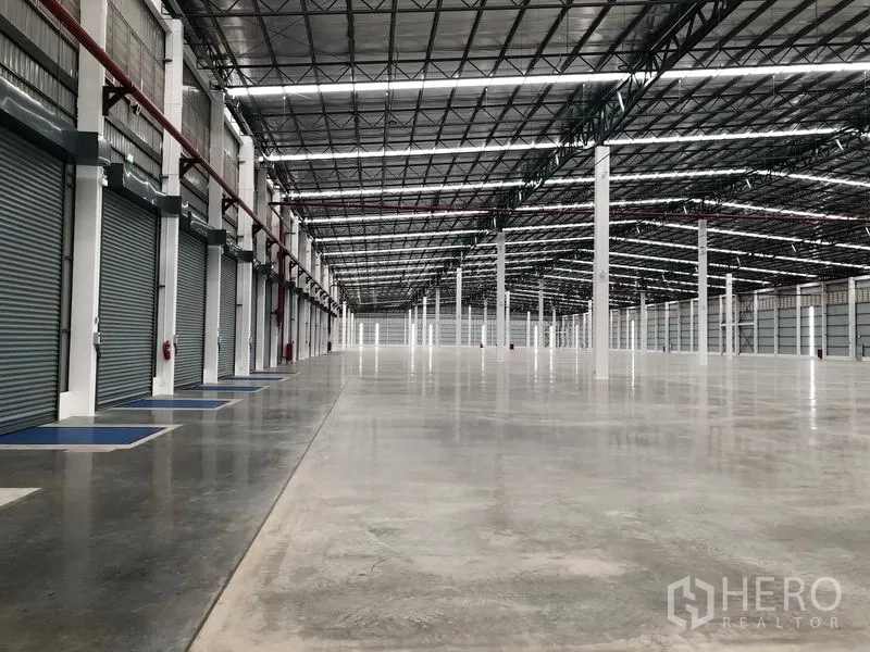 工厂 出租在Wang Noi, Phra Nakhon Si Ayutthaya - 仓库内部一排电动卷闸门与广阔作业地面