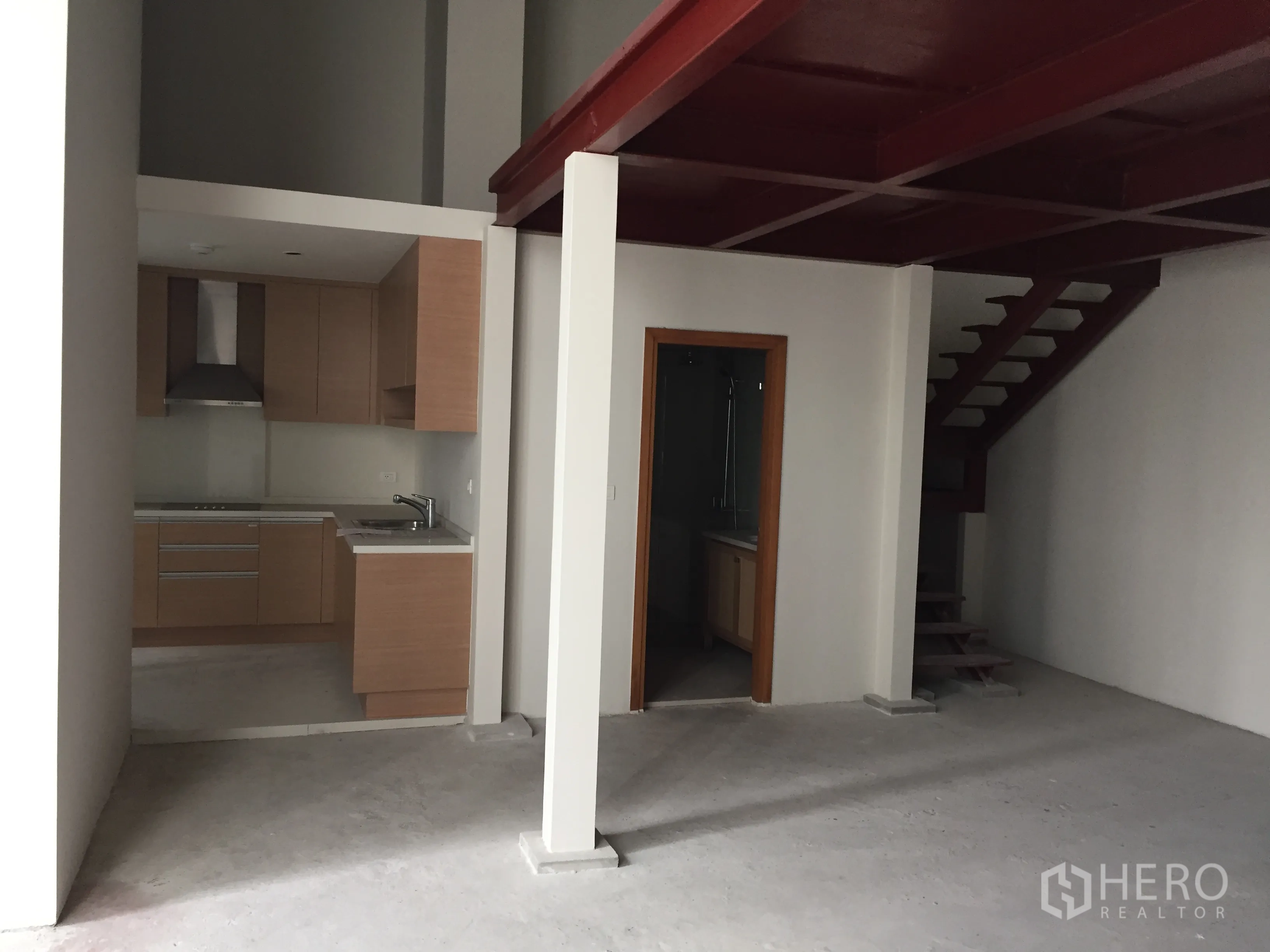 คอนโด ขายในKhlong Toei, Bangkok - พื้นที่นั่งเล่นแบบเพดานสูงพร้อมชั้นลอยและครัวบิวท์อินลายไม้.