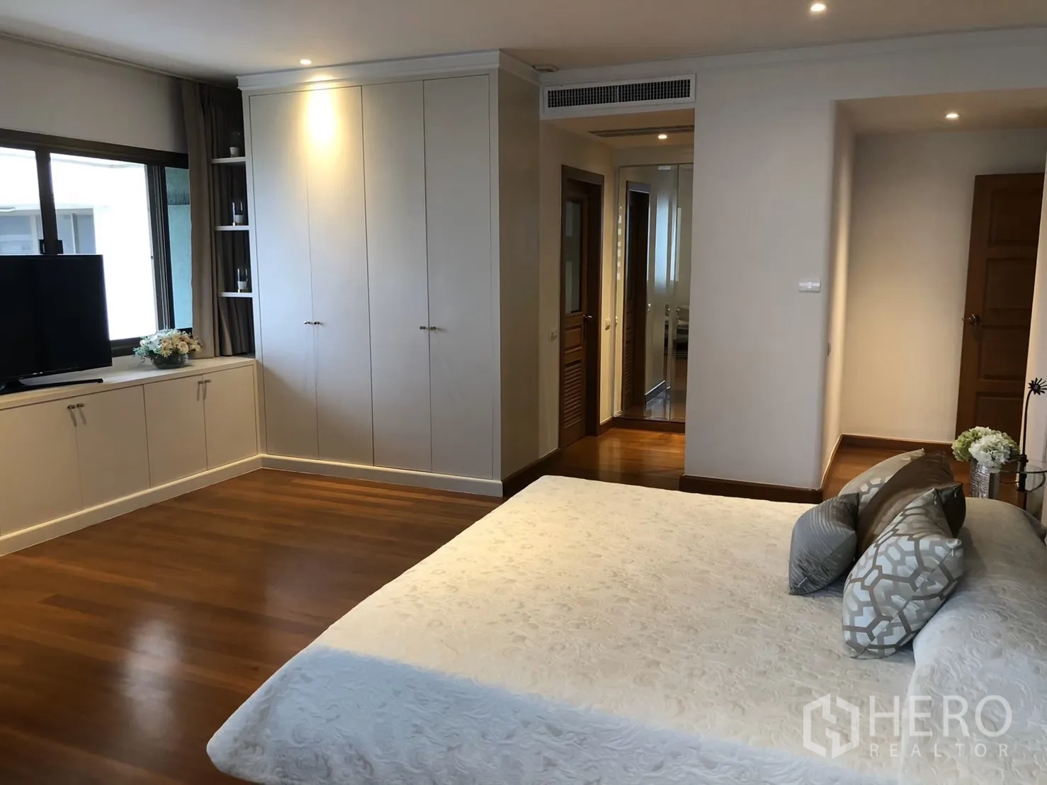 คอนโด ให้เช่าในBangkok - มุมห้องนอนพร้อมตู้บิวท์อิน ทีวี และพื้นไม้โทนอุ่น