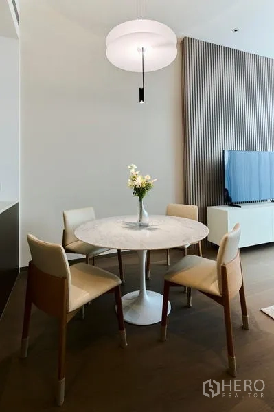 Condominium for rent in Pathum Wan, Bangkok - Cozy dining nook with a round marble table, four chairs and a modern pendant light.