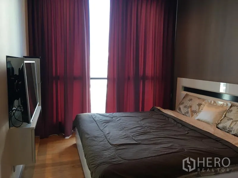 คอนโด ให้เช่าหรือขายในWatthana, Bangkok - ห้องนอนพร้อมหน้าต่างบานใหญ่ ทีวีติดผนังตรงข้ามเตียง และผ้าม่านแดง