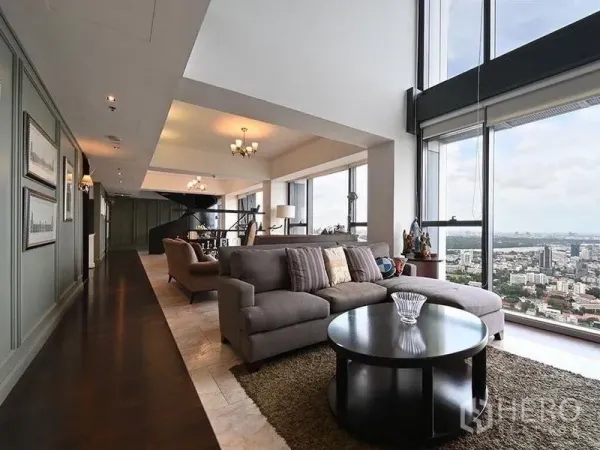 Condominium for rent in Sathon, Bangkok - Expansive lounge with sectional sofa, tall windows and unobstructed Bangkok skyline.