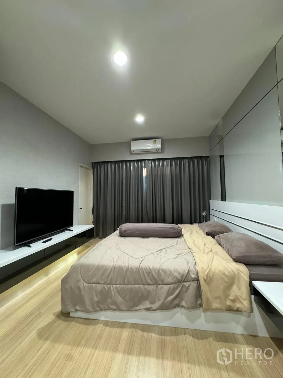 联排别墅 for rent in Suan Luang, Bangkok - 主卧配大床、电视柜、空调与落地窗帘。