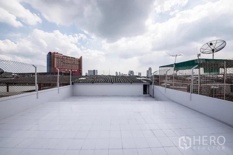 Home Office for sale in Bang Kho Laem, Bangkok - Spacious tiled rooftop terrace with mesh fencing and city skyline views near the river.