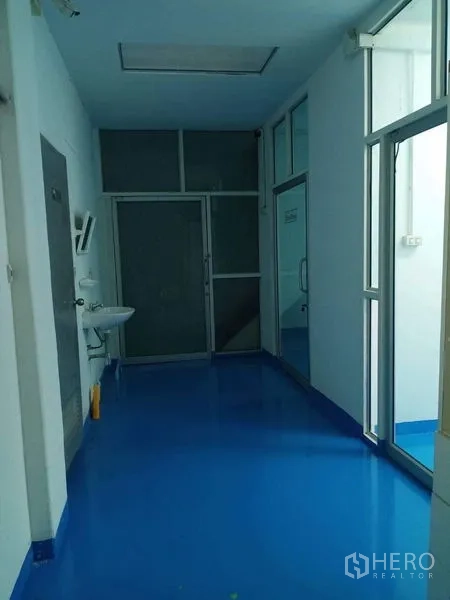 โรงงาน ขายในPathum Thani - โถงทางเดินอุตสาหกรรมพื้นอีพ็อกซี่สีน้ำเงิน พร้อมอ่างล้างมือและประตูกระจก