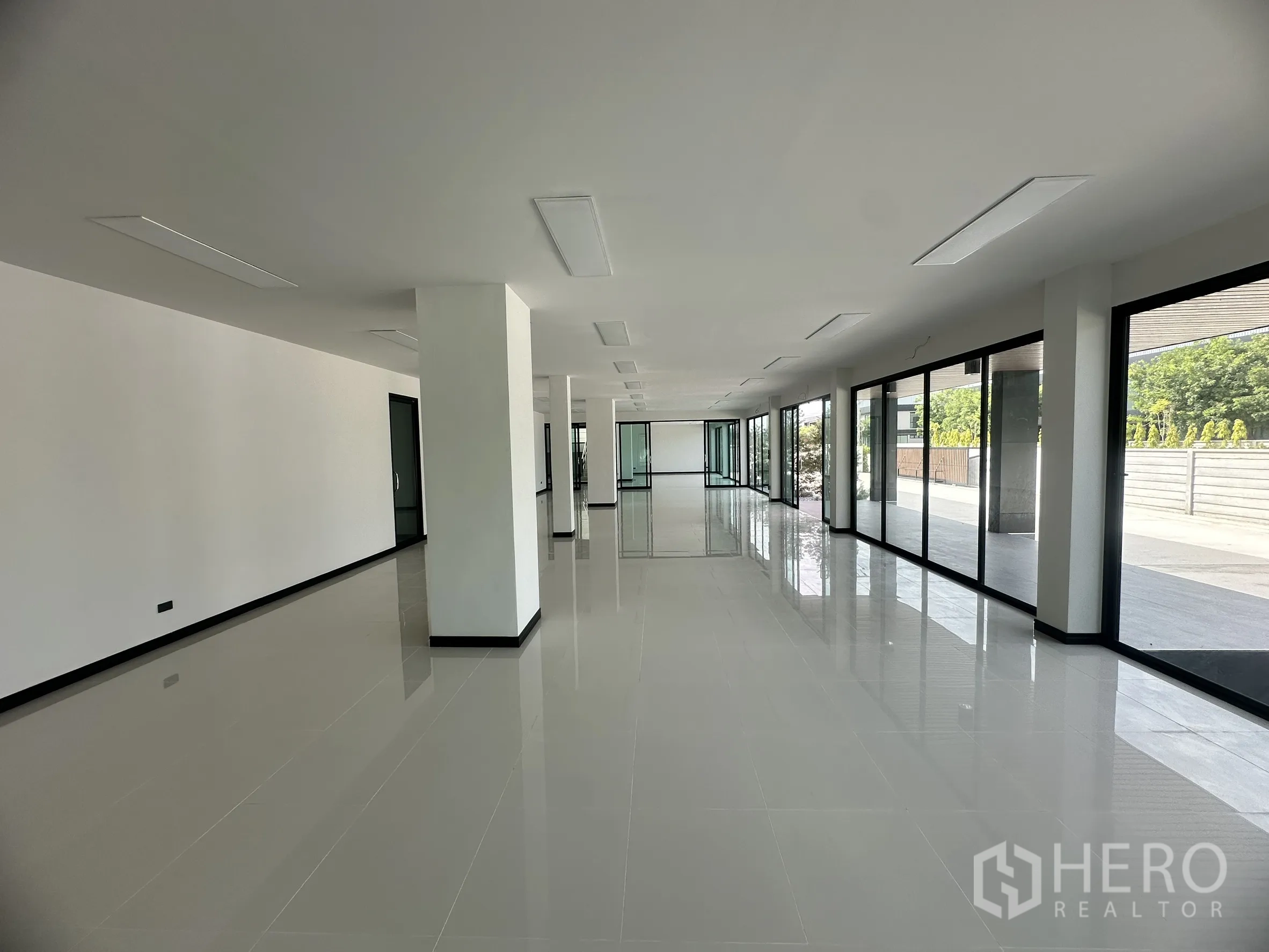 Factory for rent or sale in Bang Len, Nakhon Pathom - Bright office interior with white tiled floors, glass partitions, and floor-to-ceiling windows.