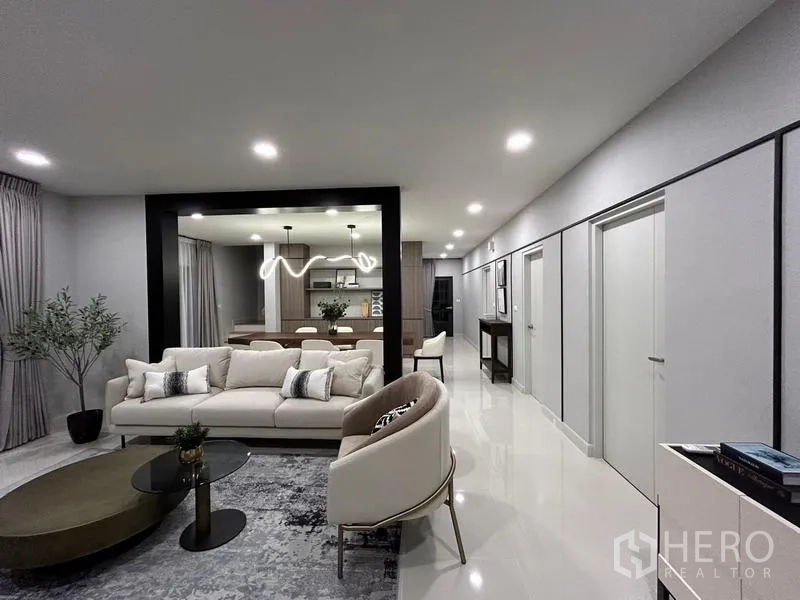 Detached House for rent or sale in Bang Phli, Samut Prakan - Open‑plan living area flowing to the dining zone under sculptural pendant lighting.