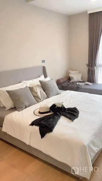 公寓 出租在Watthana, Bangkok - 静谧卧室，特大床、叠层靠枕与窗边休憩位。