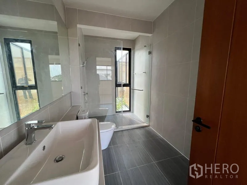 สำนักงานที่บ้าน ขายในPhra Khanong, Bangkok - ห้องน้ำสไตล์โมเดิร์น พร้อมตู้กระจกอาบน้ำ อ่างล้างหน้า และหน้าต่าง.