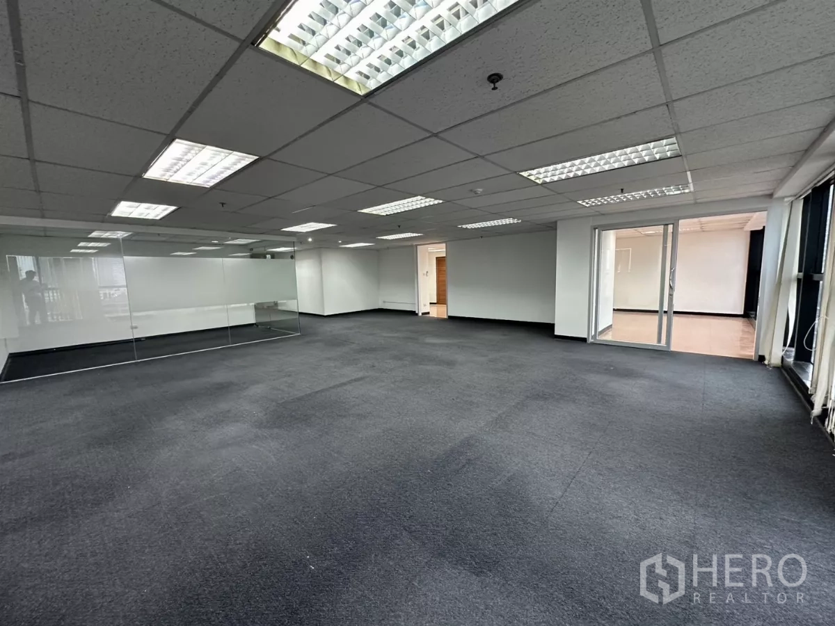 办公空间 出租在Watthana, Bangkok - 开放空间展示玻璃会议室、落地窗，并与瓷砖地辅助区相连。