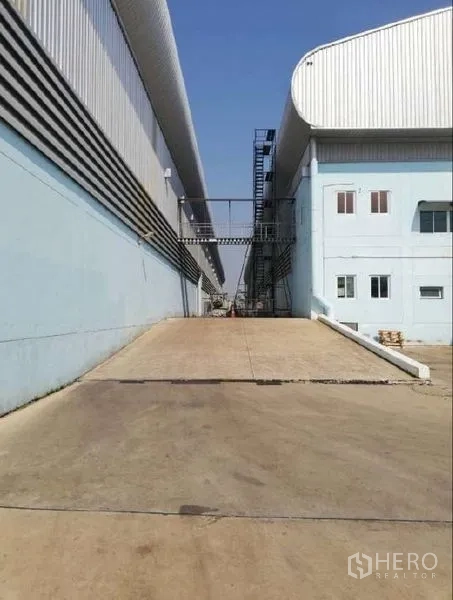 Warehouse for rent in Nong Chok, Bangkok - Service ramp between warehouse buildings with external stairs and an overhead connection bridge.
