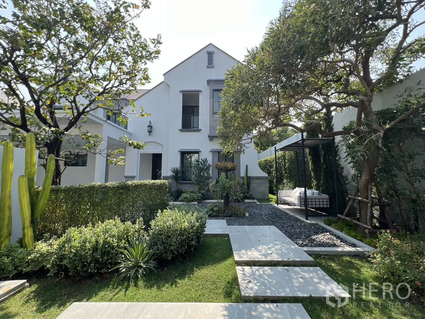 Detached House for rent in Saphan Sung, Bangkok - Full garden view toward the house with daybed pavilion and pathways.