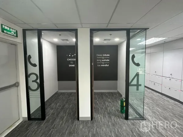 Office Space for rent in Khlong Toei, Bangkok - Two compact phone booths with glass doors and motivational wall text.