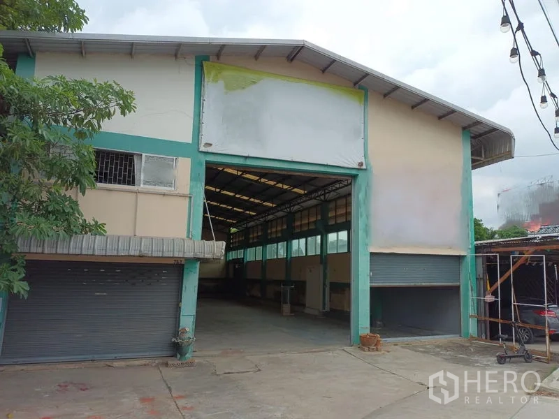 Warehouse for rent in Phasi Charoen, Bangkok - Warehouse front facade with wide entrance, roller shutters and driveway.