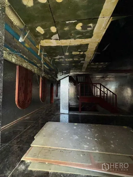 อาคารพาณิชย์ ให้เช่า - ภายในเพดานบุฉนวน บันไดสีแดง และแผ่นวัสดุกอง
