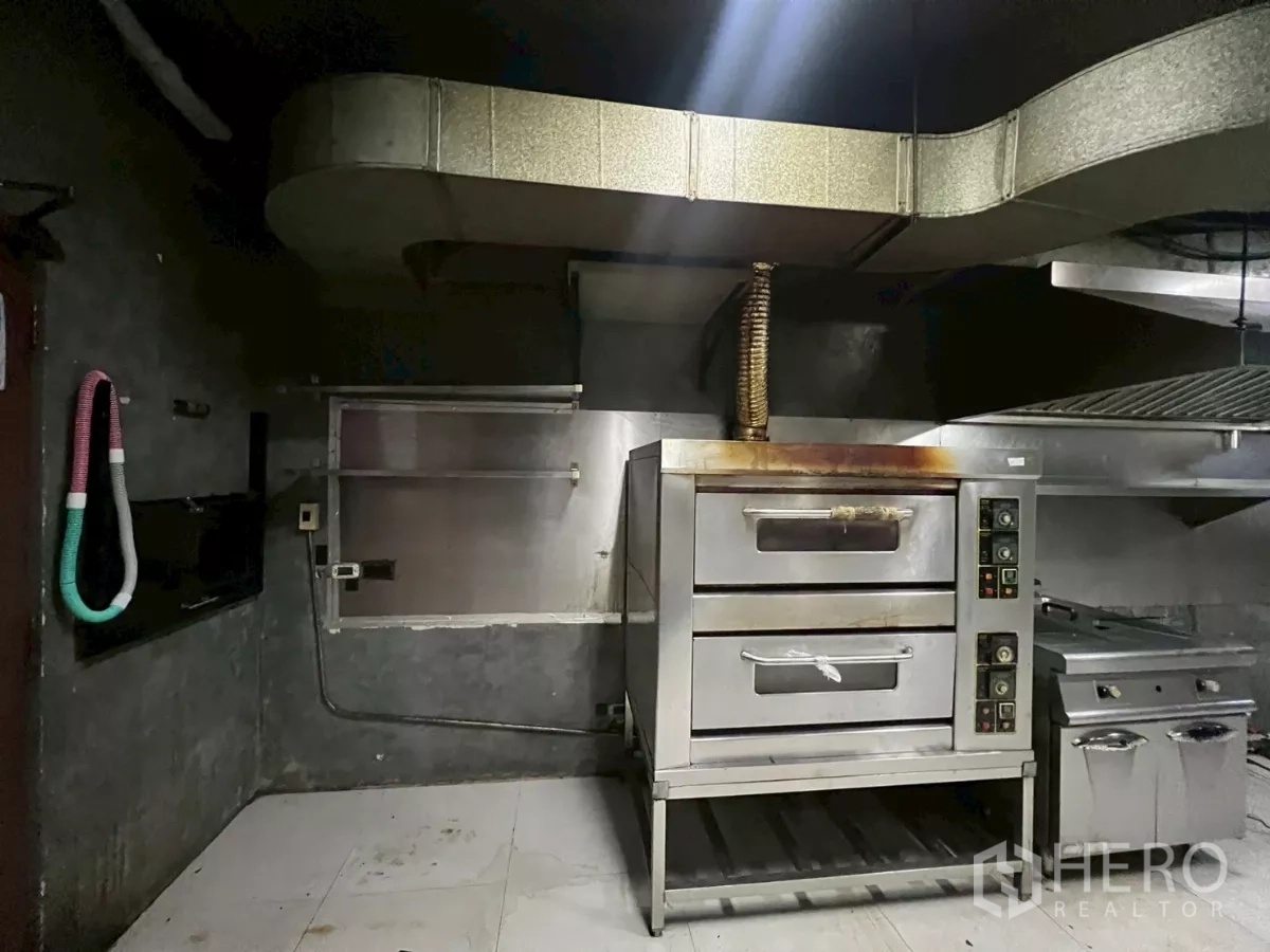 零售空间 出租 - 双层披萨烤炉与油炸炉，连接通风管道的特写。