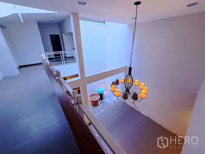 店屋 出租在Watthana, Bangkok - 夹层走道俯瞰中庭与装饰吊灯。